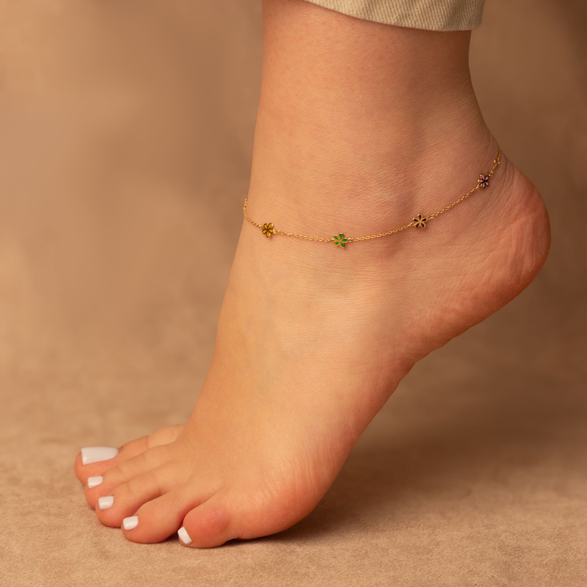 Solid 14K yellow gold enamel flower anklet worn at the ankle