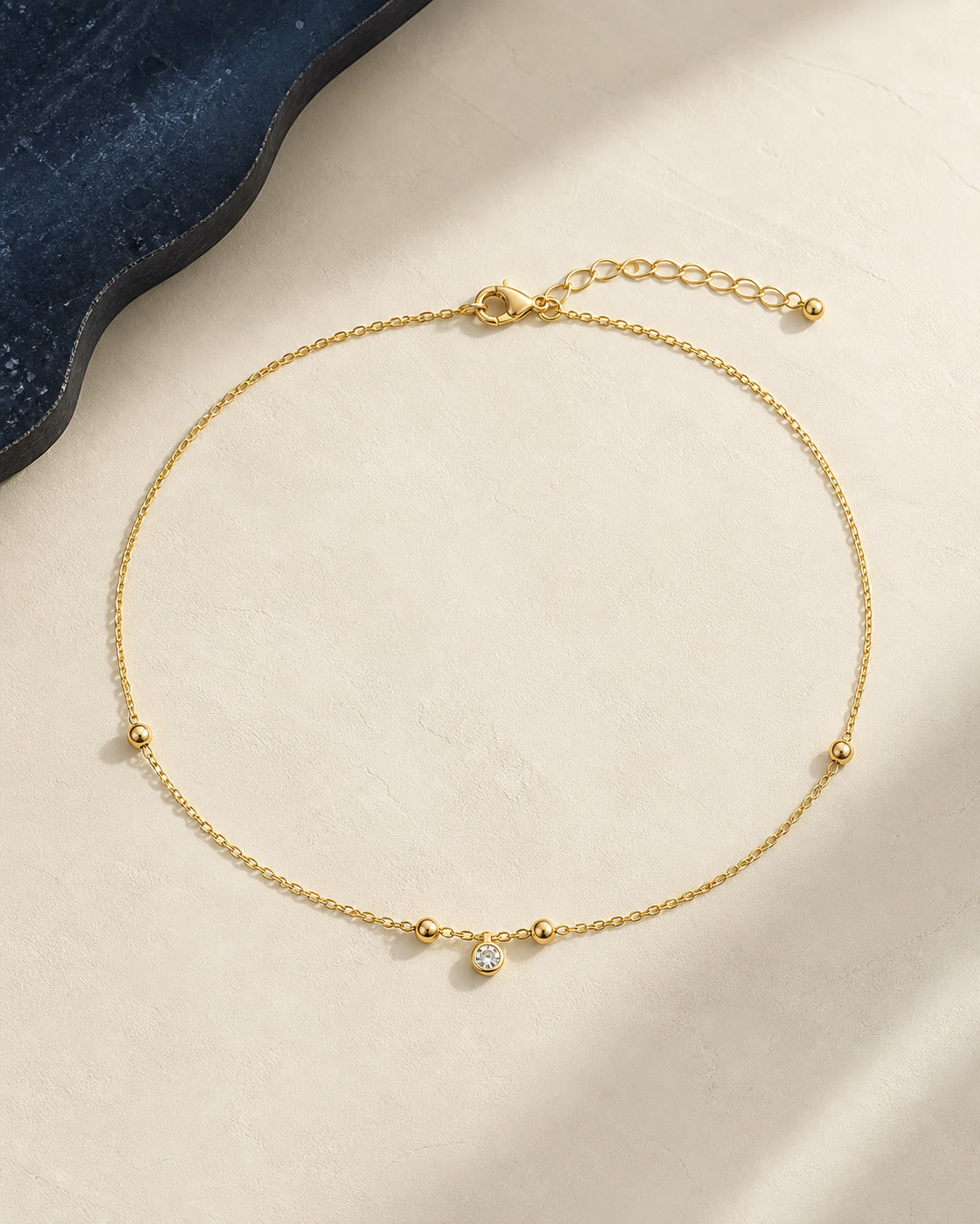 An editorial arrangement of yellow-gold anklets