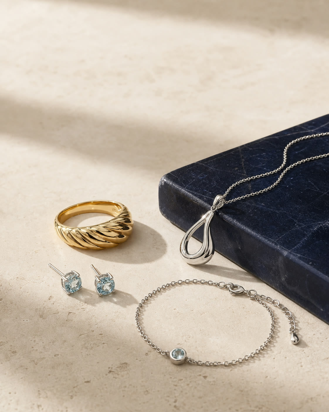 A curated jewelry edit arranged on warm ivory stone