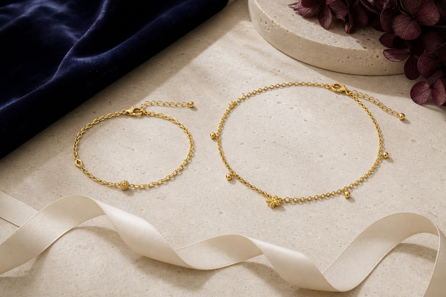 A yellow-gold bracelet and anklet arranged beside a soft measuring ribbon